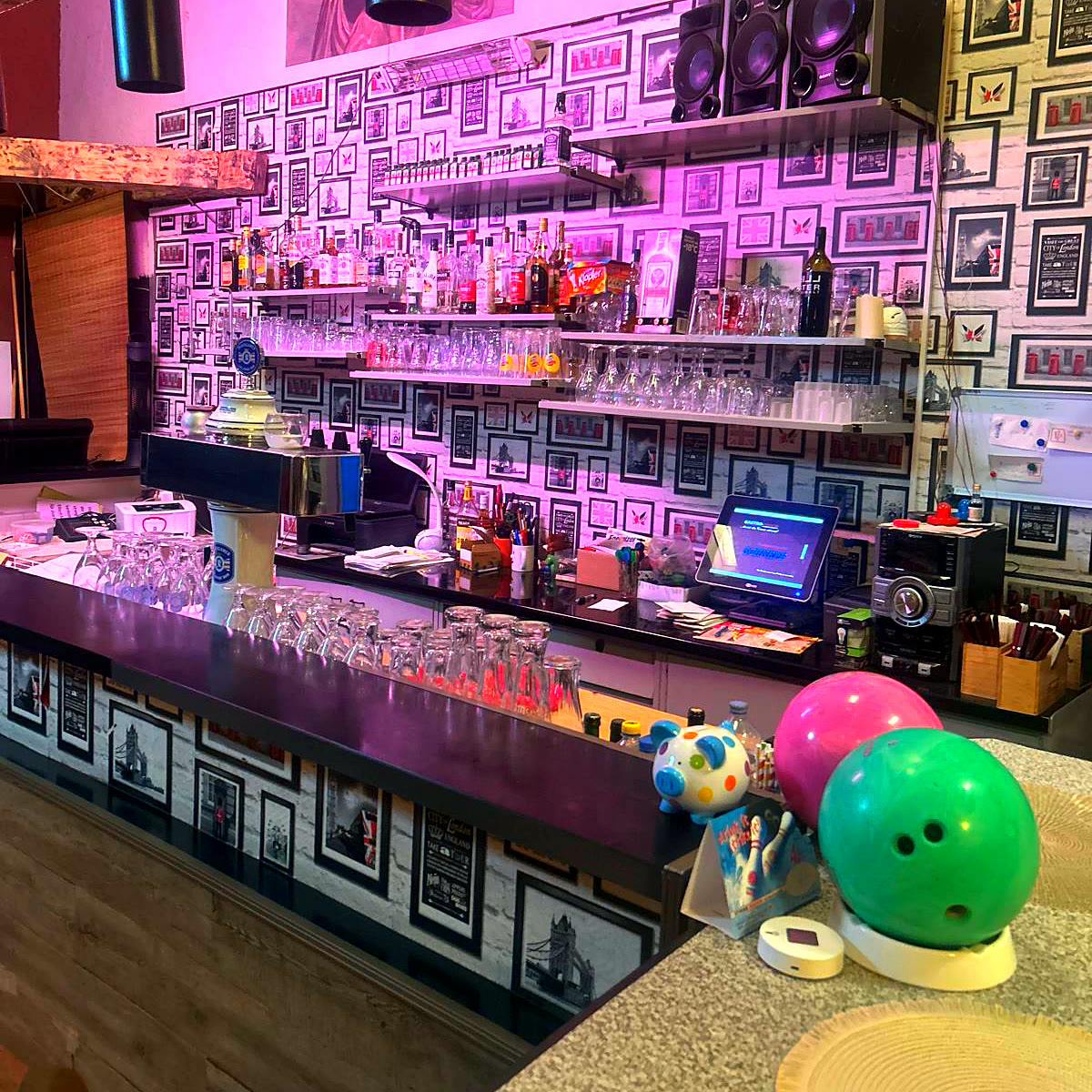 Die Bar mit Flaschen, Gläsern und zwei Bowlingkugeln
